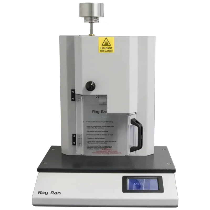 This image is of a laboratory device, specifically a melt flow indexer. The machine is gray and white, with a warning label indicating a hot surface at the top. It has a clear panel in the front, labeled "Ray Ran," and a small display screen at the bottom right on the base.