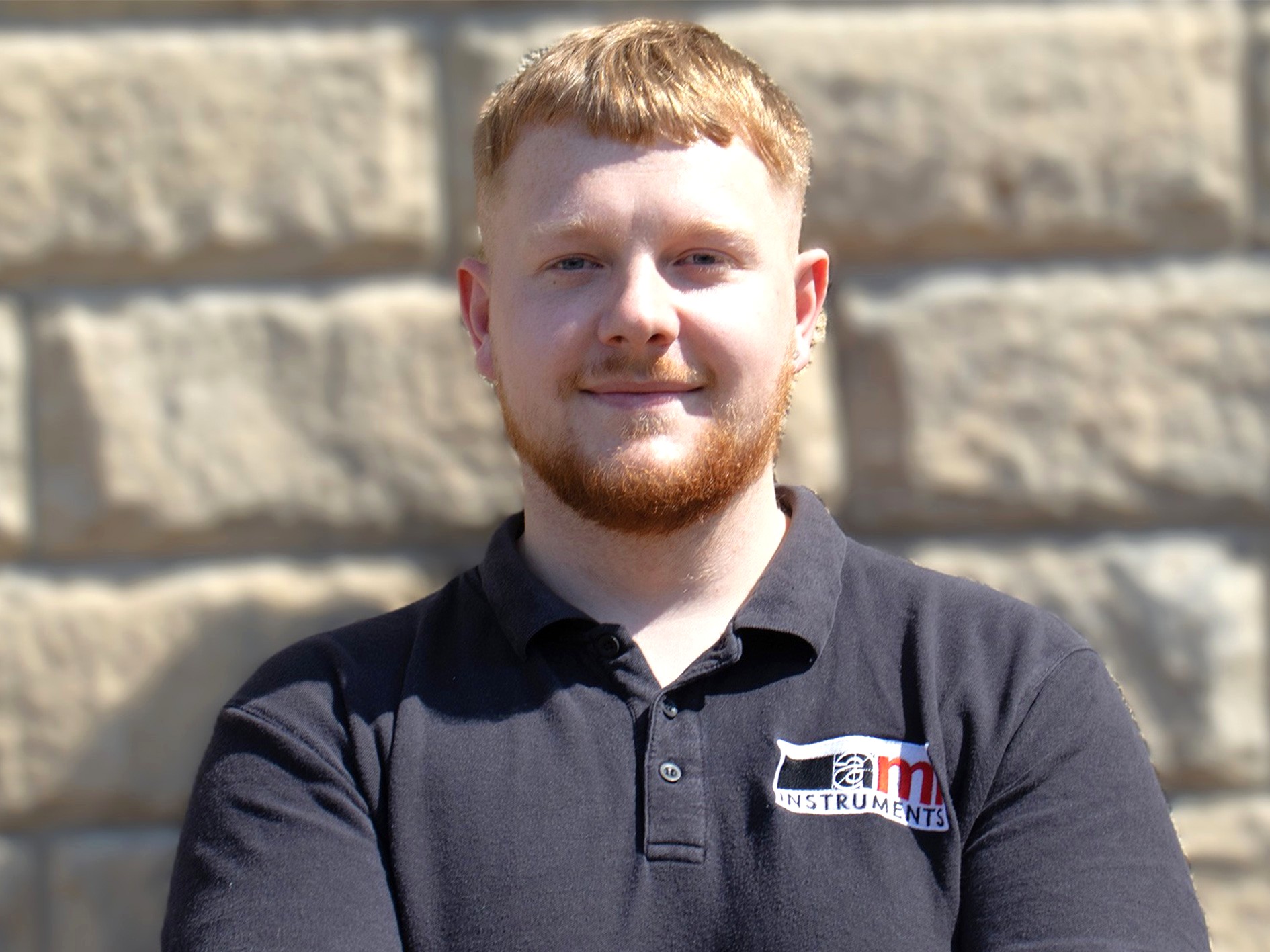 AML Instruments calibration engineer Shane Easton wearing a branded black polo shirt in an outdoor professional photograph.