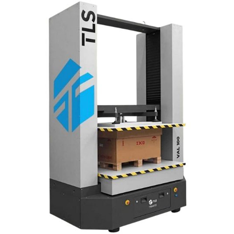 Side-angle view of VAL-100 testing a large box on a pallet, with visible TLS logo and sturdy build.